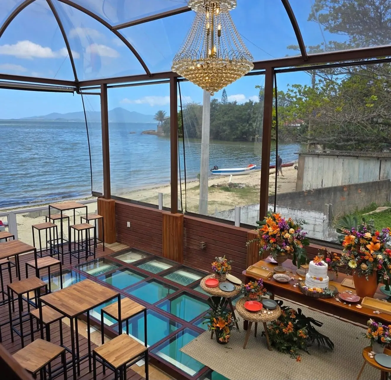 Salão com vista para o mar e decoração de casamento