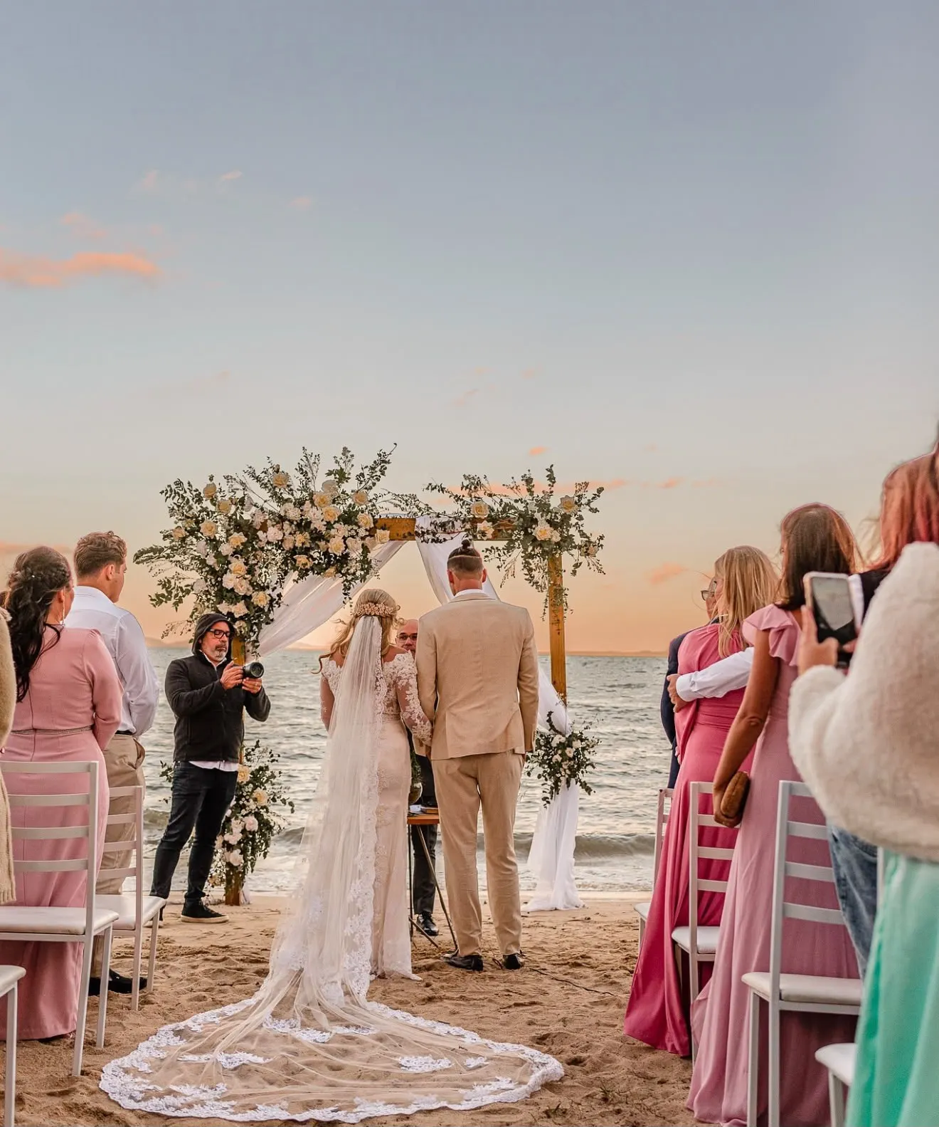 Casal se casando ao pôr do sol na praia